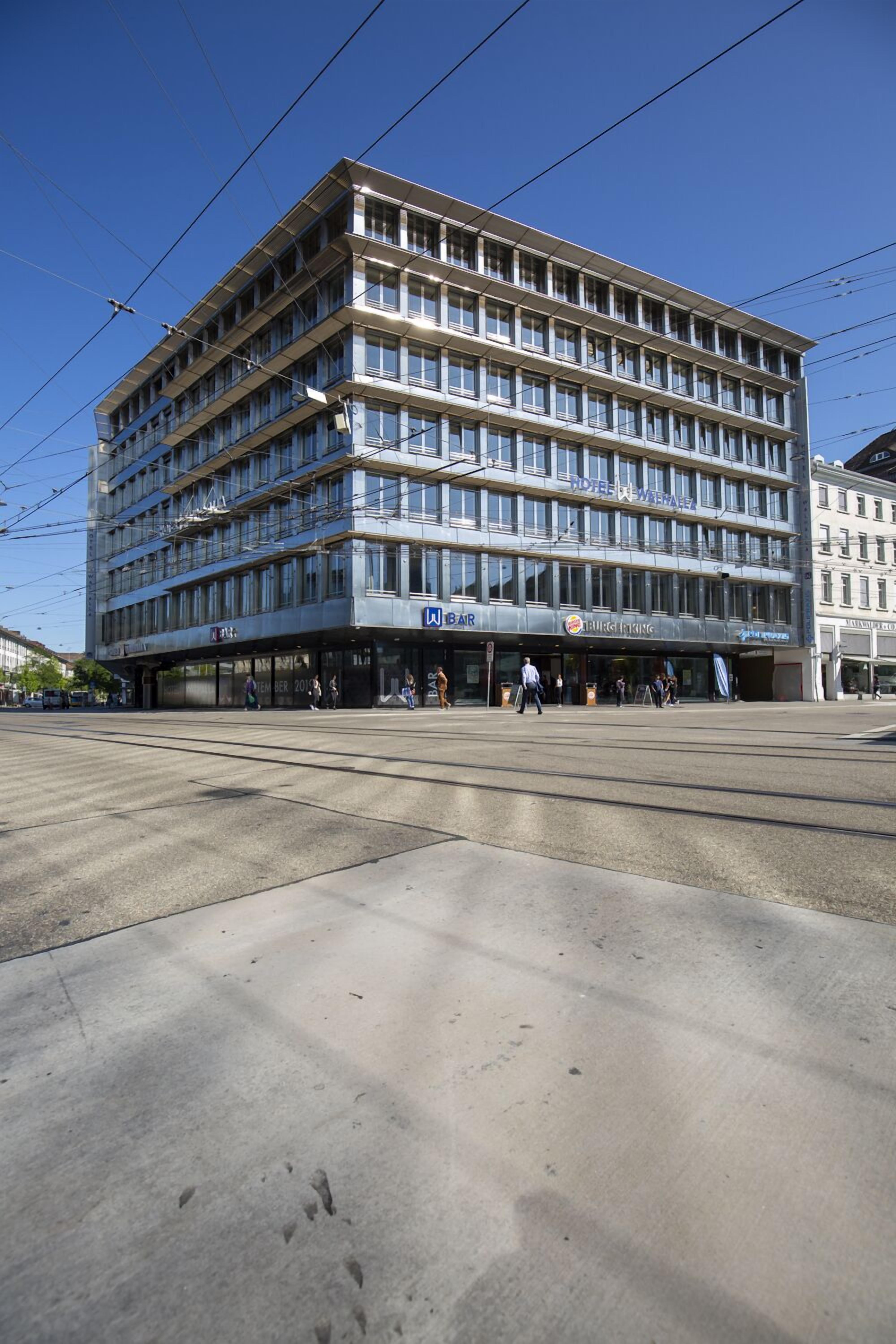 A multi-story hotel with a modern design, featuring a bar and restaurant on the ground floor.
