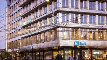 A multi-story hotel with a bar on the ground floor.