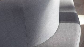 A close-up of a modern, curved sofa with a textured fabric.