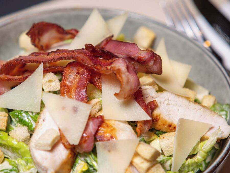 Ensalada con lechuga, pollo, queso y tocino.