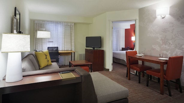 A hotel room with a bed, a desk with a chair, a television, and a dining area with chairs and a table. - Residence Inn by Marriott San Antonio Downtown Market Square (San Antonio)