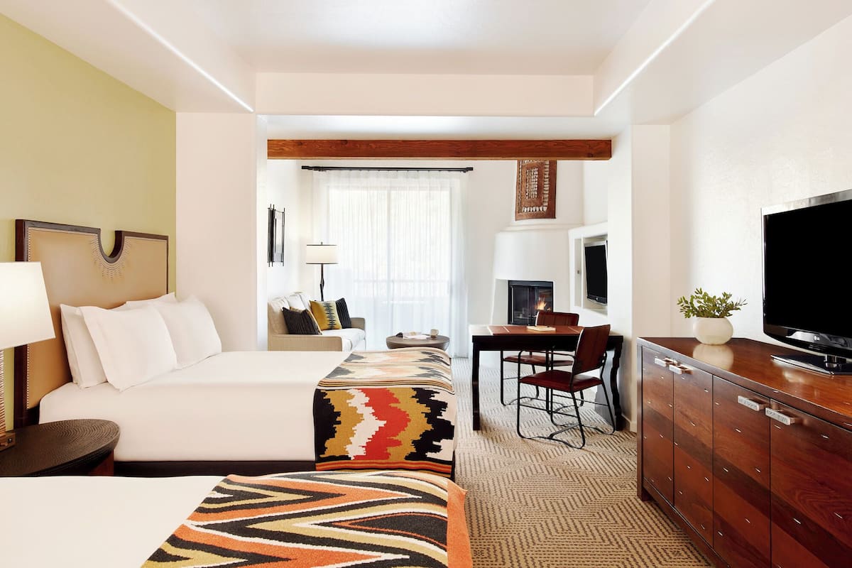 A hotel room with a bed, a desk, a television, and a cabinet.