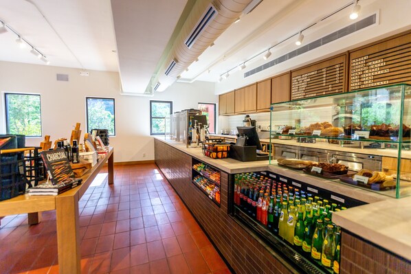 A café with a counter, beverage dispensers, and a display case with pastries. - Enchantment (Sedona)