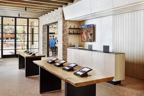 A reception area with a long wooden reception desk, stone wall, and a view of the outdoors.
