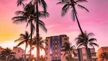 A multi-story building with a modern architectural style, surrounded by palm trees.