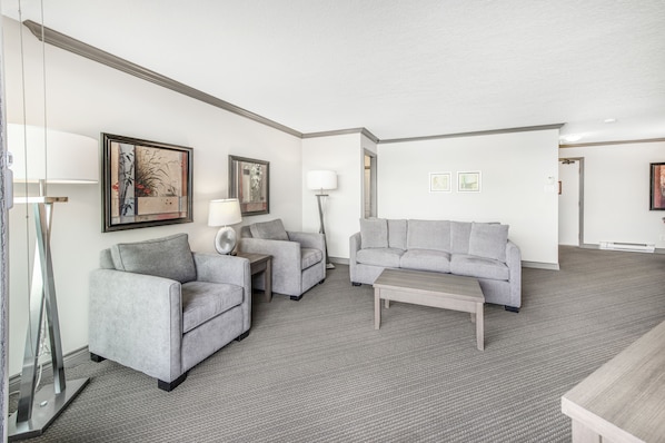 A modern living room with two grey sofas, a coffee table, and a floor lamp.