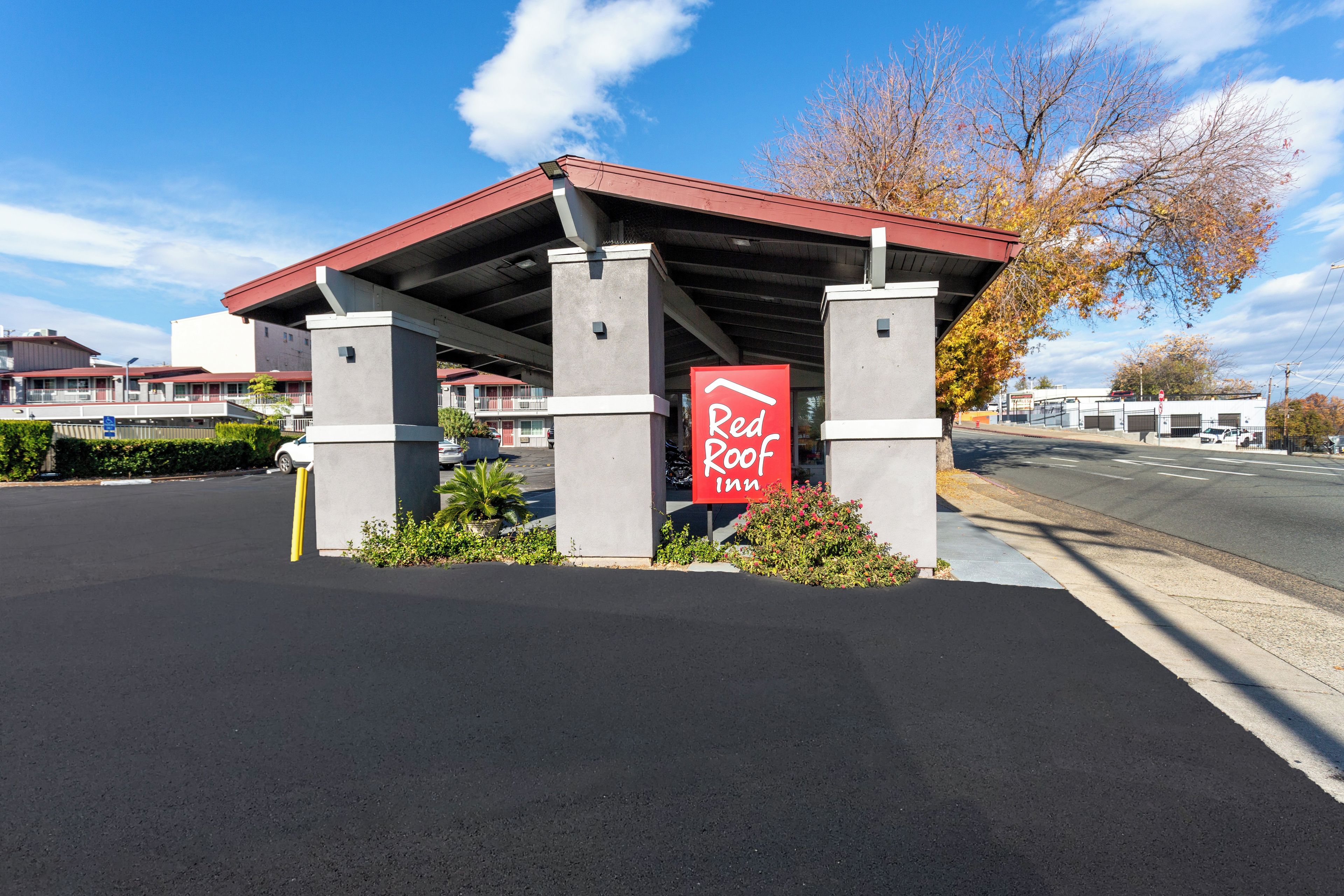 A Red Roof Inn with a covered parking area and a clear sky.