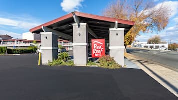 A Red Roof Inn with a covered parking area and a clear sky.