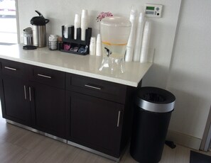A kitchenette with a coffee machine, a water dispenser, and a trash bin. - Red Roof Inn Redding (Redding)