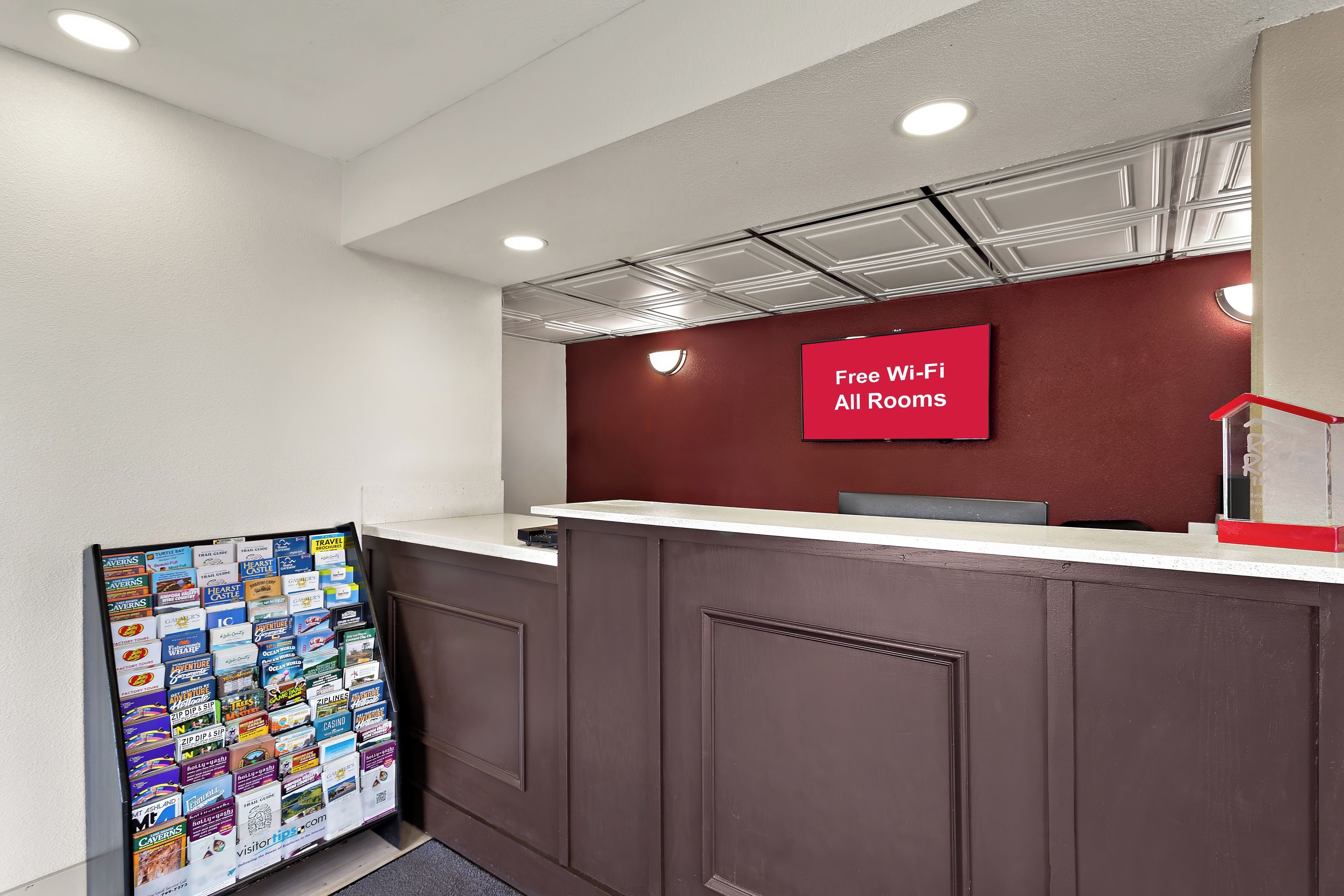 A reception desk with a red sign indicating free Wi-Fi in all rooms.