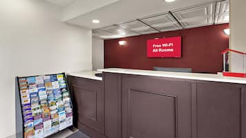 A reception desk with a red sign indicating free Wi-Fi in all rooms.