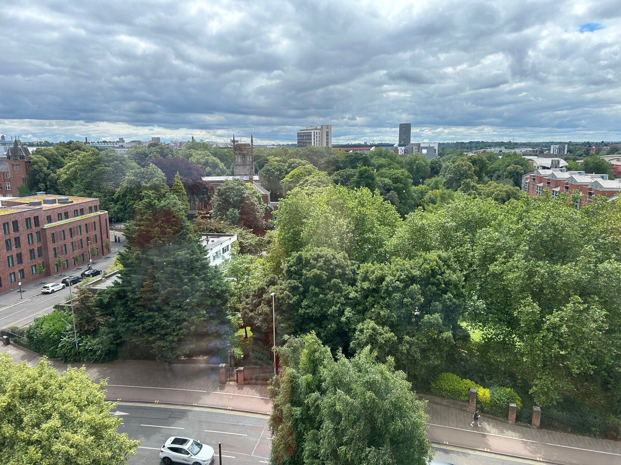 A cityscape with buildings, trees, and a road.