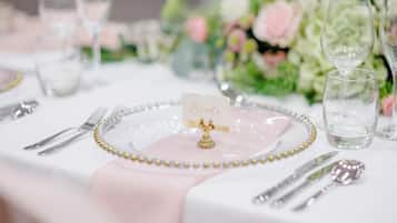 A table setting with a 'Bride' placemat, a pink napkin, and a gold beaded border.