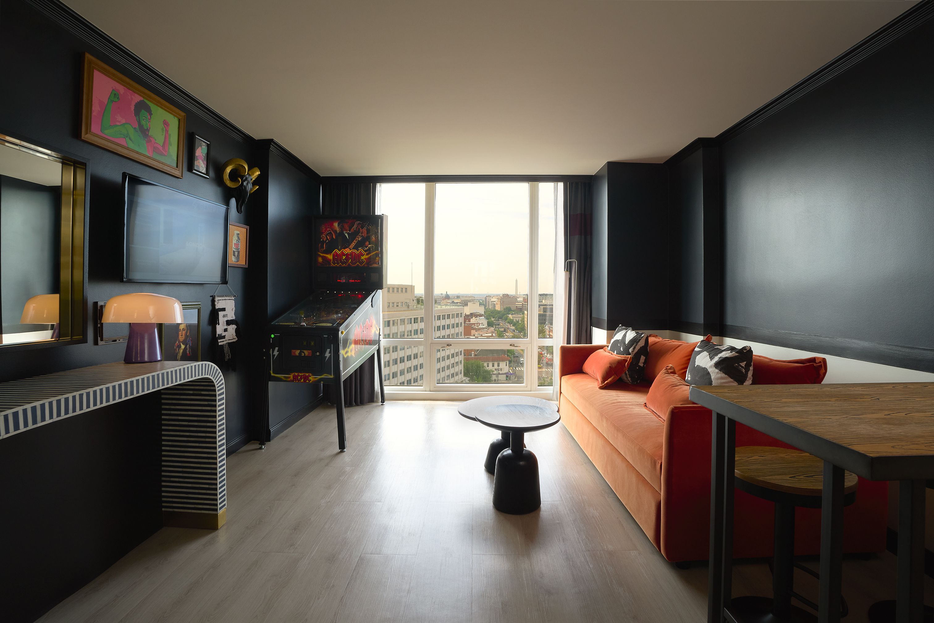 A modern living room with a sofa, a coffee table, and a flat-screen TV mounted on the wall.