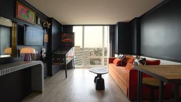 A modern living room with a sofa, a coffee table, and a flat-screen TV mounted on the wall.