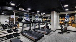 A gym with treadmills, dumbbells, and exercise bikes.