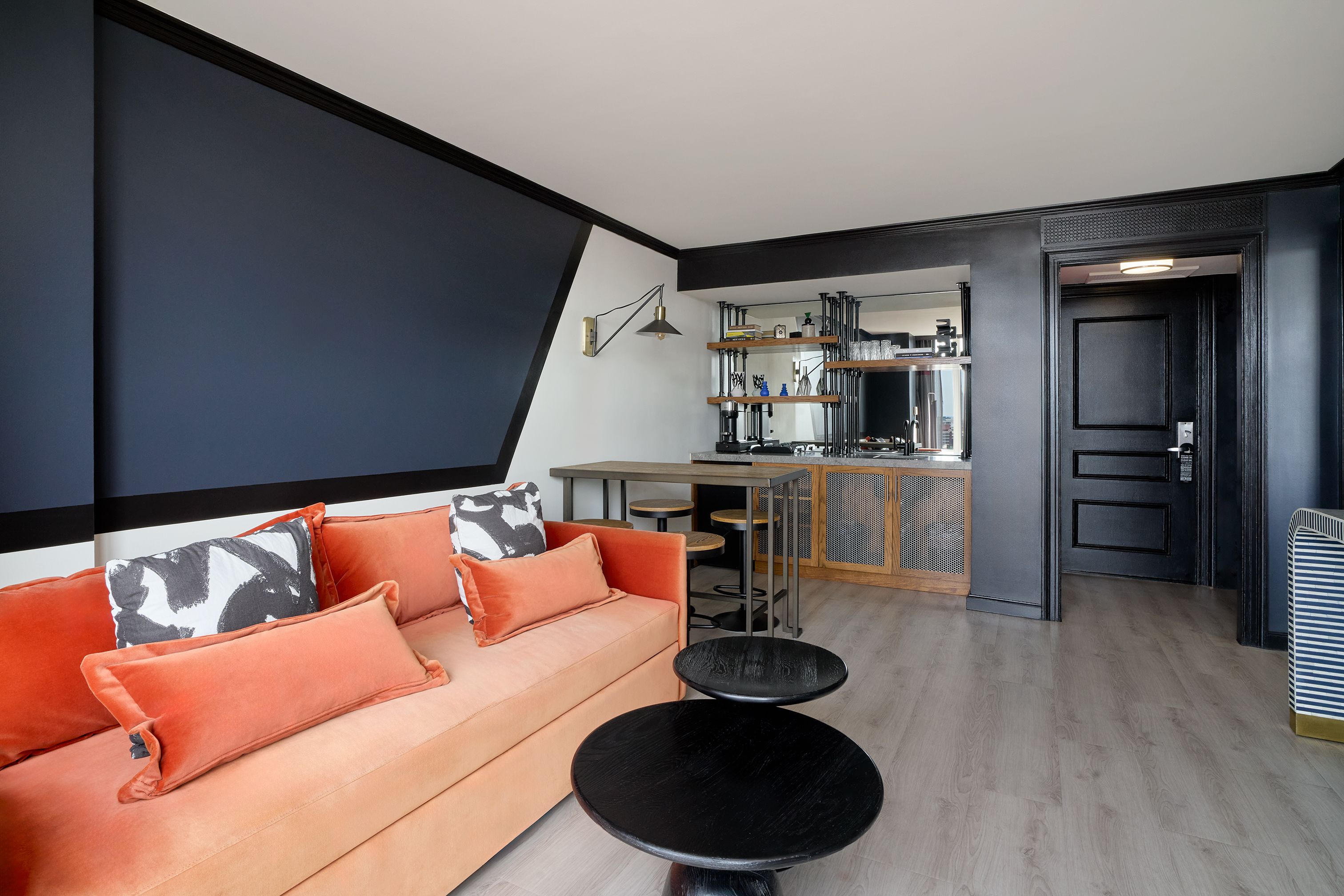 Un espace de vie moderne avec un canapé, une table ronde et une cuisine en arrière-plan.