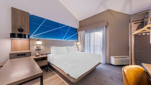 A modern hotel room with a bed, bedside tables, a desk, a wardrobe, and a large window with curtains. - Comfort Inn & Suites Irvine Spectrum (Lake Forest)