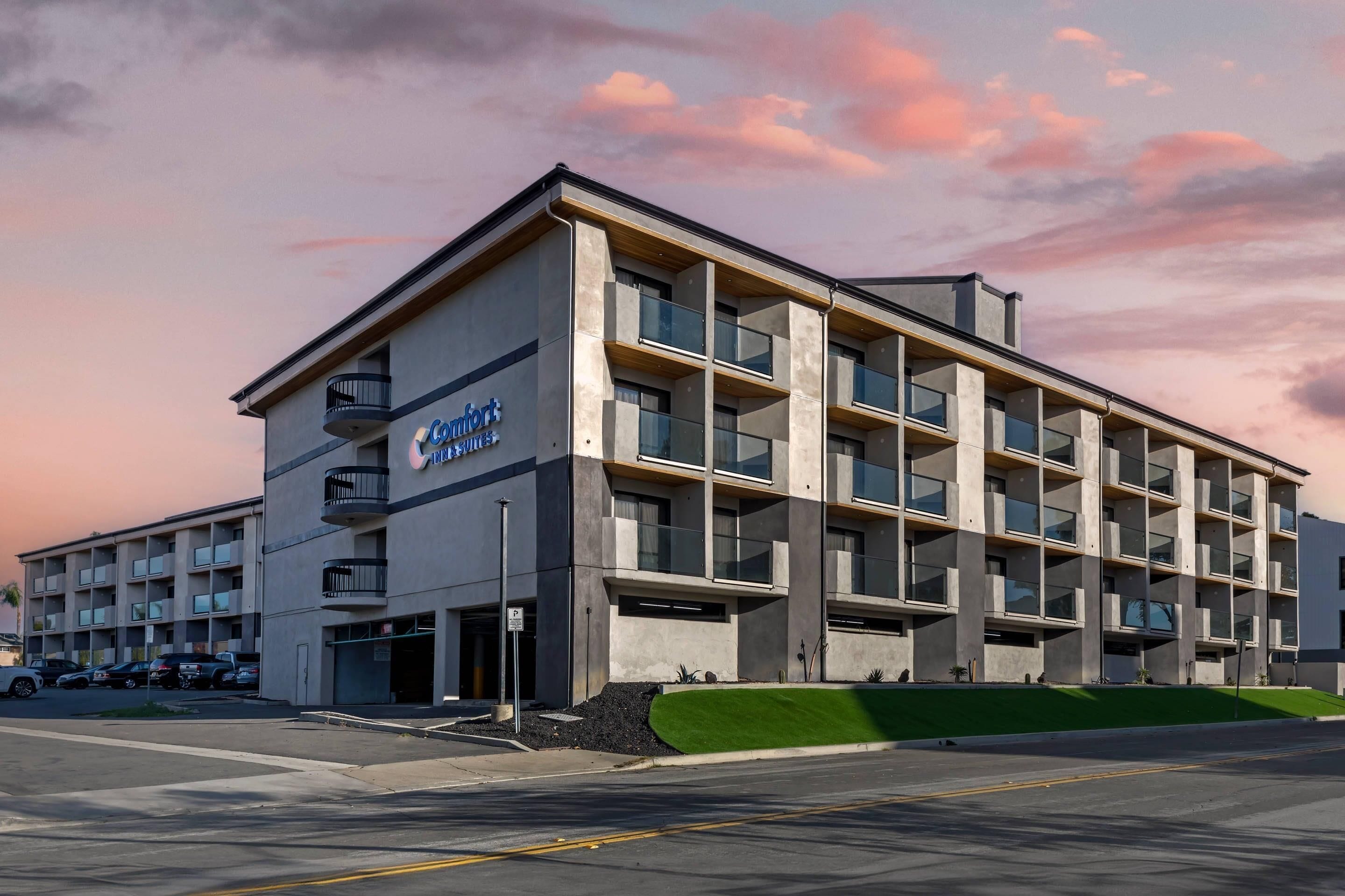A modern hotel building with a flat roof, multiple balconies, and large windows.