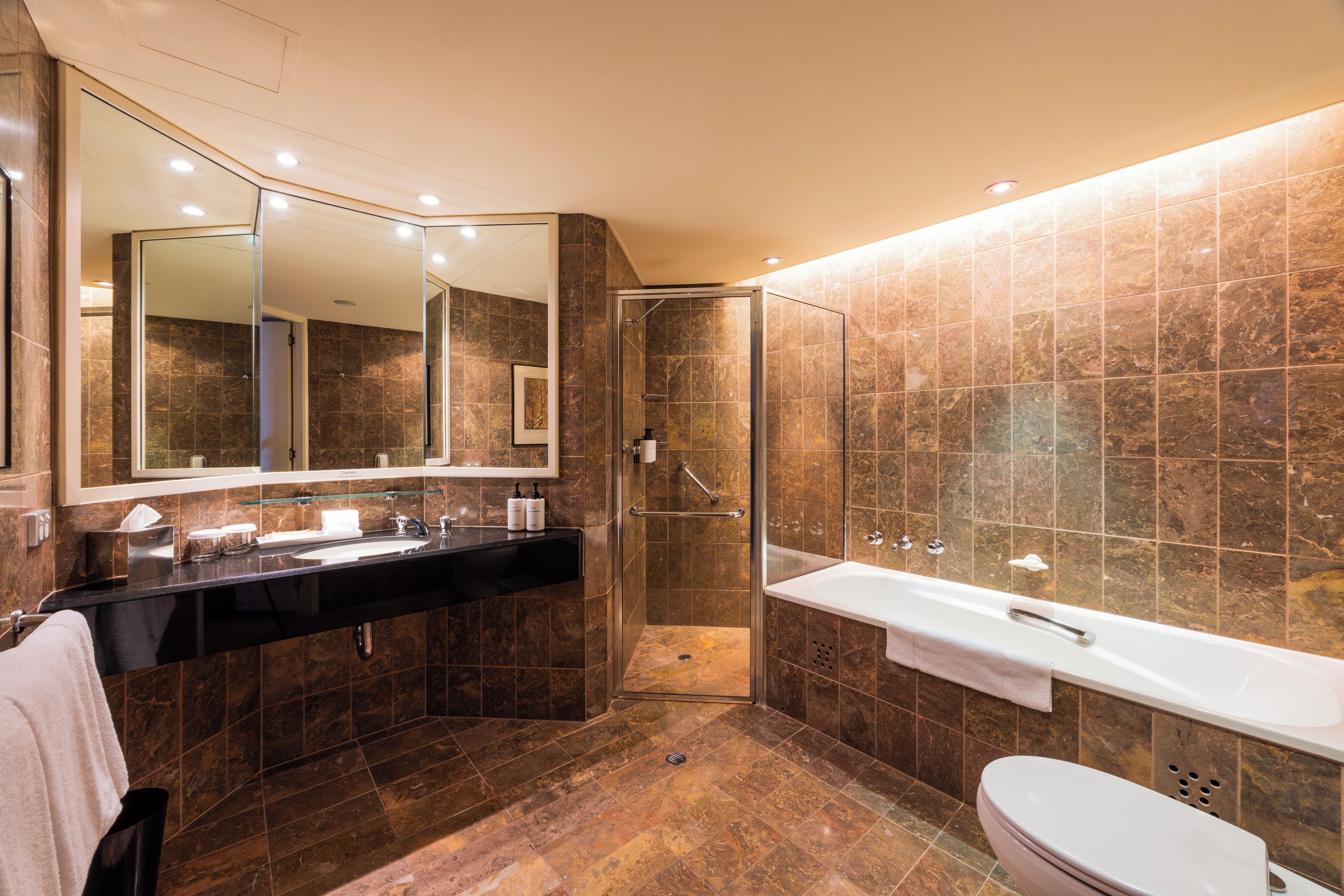 A modern bathroom with a walk-in shower, a large bathtub, and a double sink vanity.