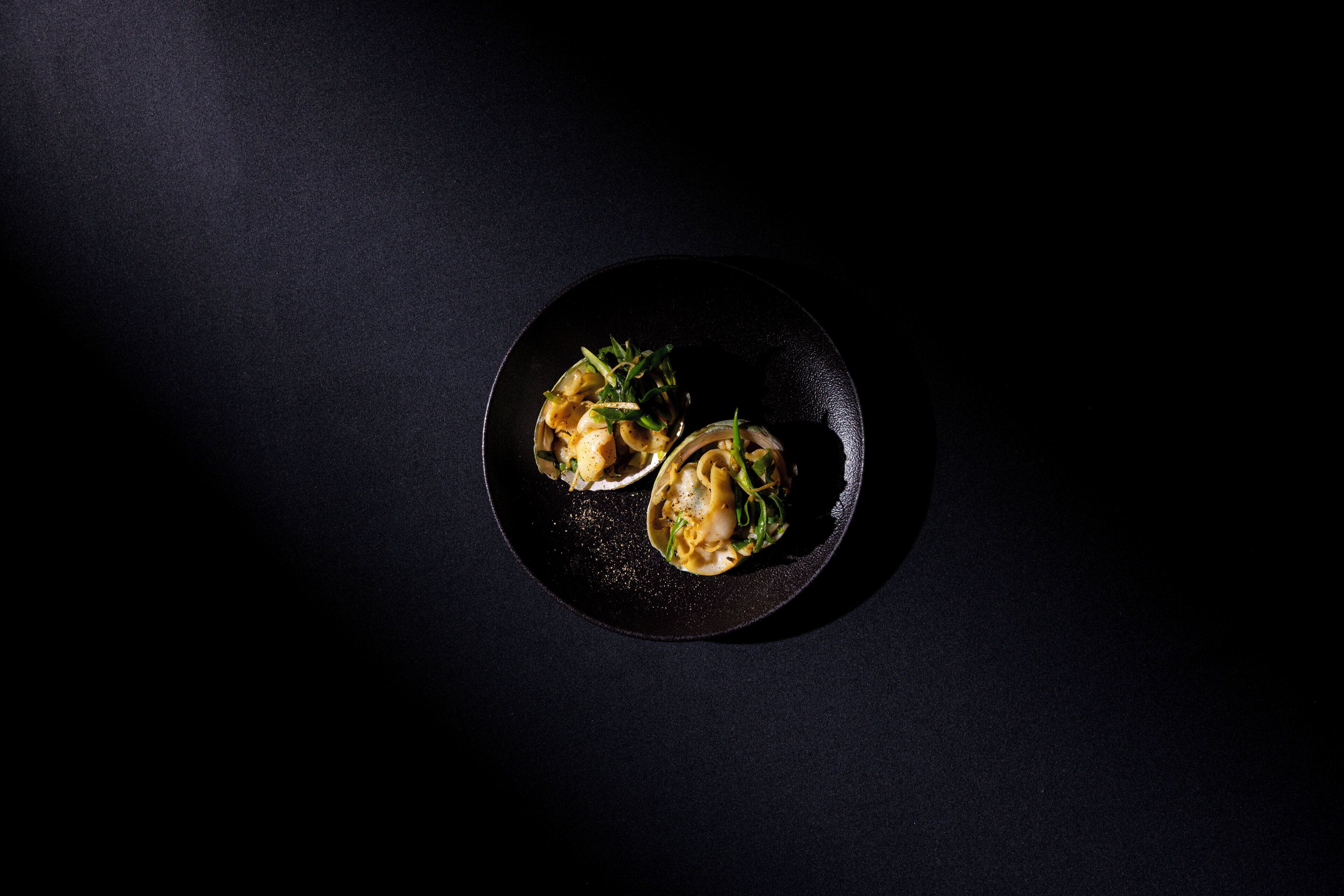 Une assiette contenant trois aliments, posée sur une surface sombre.
