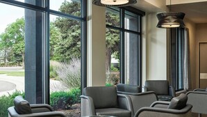 A modern lobby with large windows, comfortable seating, and a stylish pendant light. - Courtyard by Marriott Boulder (Boulder)