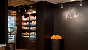 A modern interior with a refrigerated display and shelves stocked with snacks. - Courtyard by Marriott Boulder (Boulder)