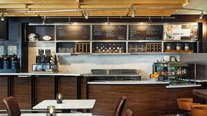 A restaurant with a bar area, wooden furniture, and a menu board. - Courtyard by Marriott Boulder (Boulder)