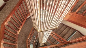 A spiral staircase with wooden railings and a modern light fixture. - The Coppid Beech Hotel (Bracknell)