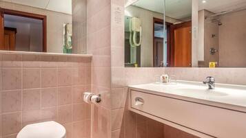 Une salle de bain avec des toilettes, un lavabo et un miroir.