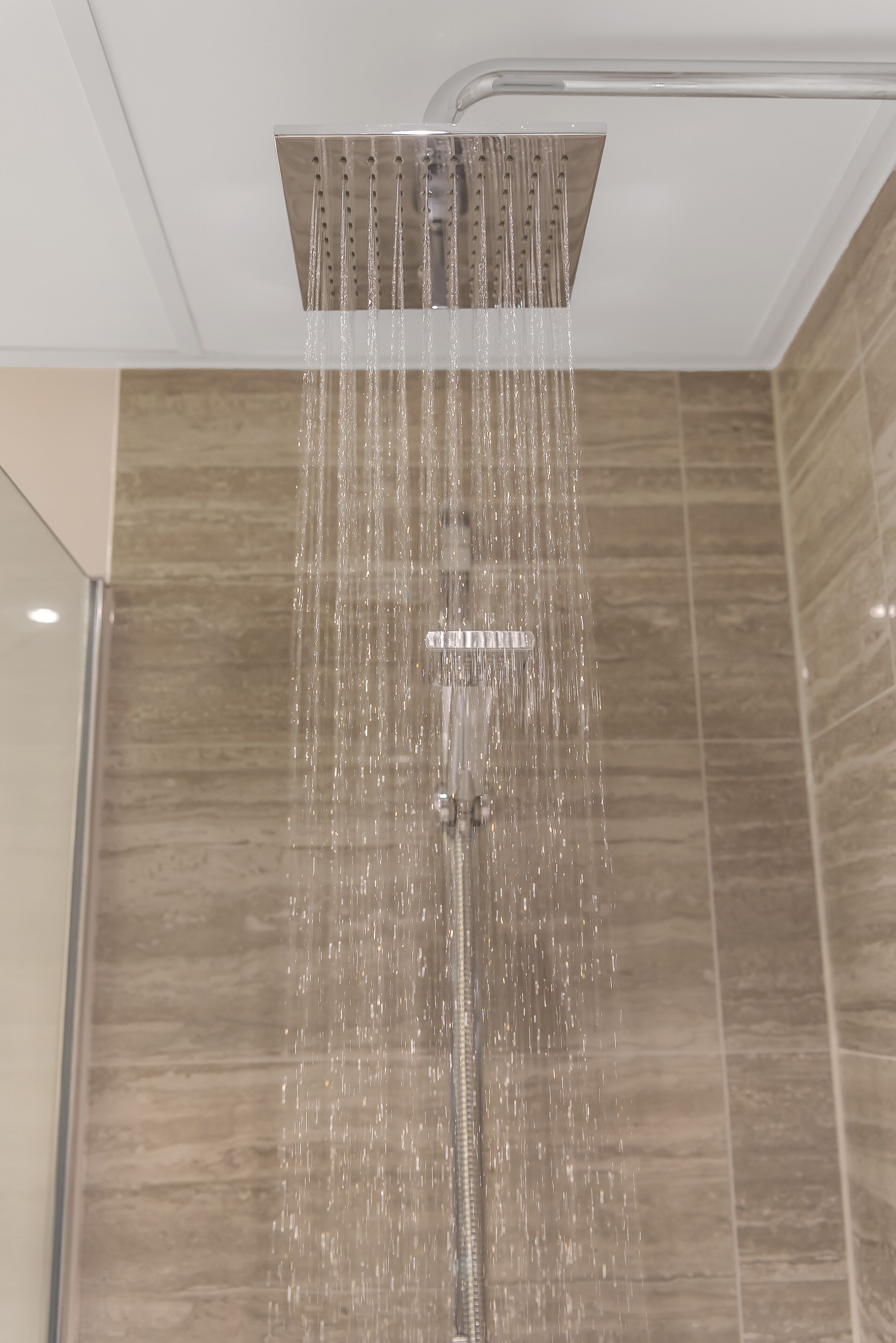 A modern shower with a square design and multiple water jets.