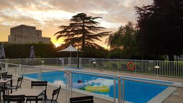 Relax by the pool surrounded by lush greenery and comfortable lounge seating.