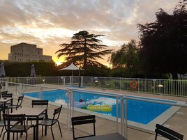 Una piscina al aire libre de temporada, sillones reclinables de piscina
