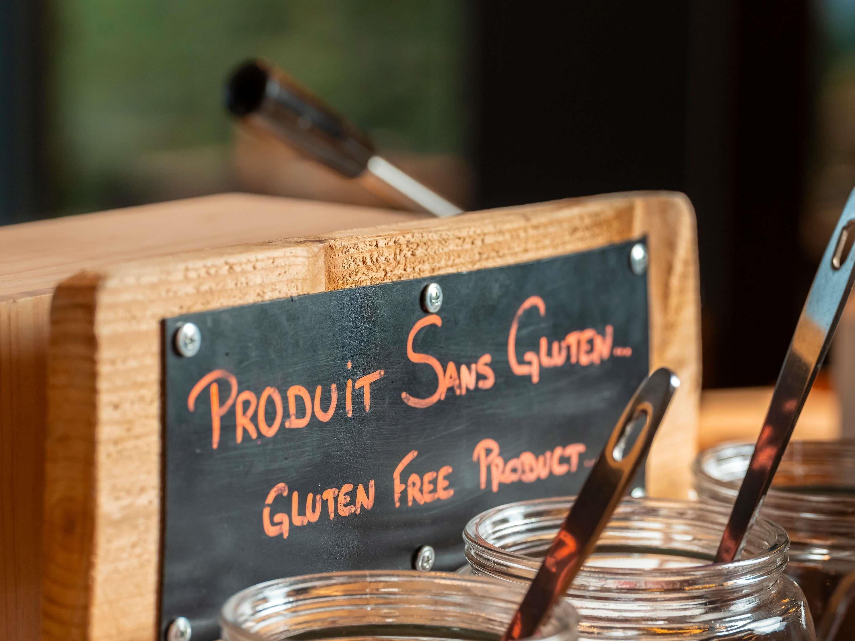A gluten-free product sign on a chalkboard, with jars and spoons in the foreground.
