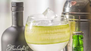 Et cocktailglas med isterninger og et agneskive, en flaske med teksten "Burleigh's London Dry" og en shaker.