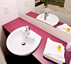 Bathroom features a sink, mirror, and a bathtub.
