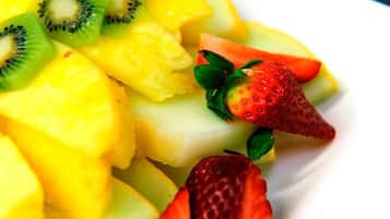 Primer plano de una ensalada de frutas con piña, kiwi y fresas.