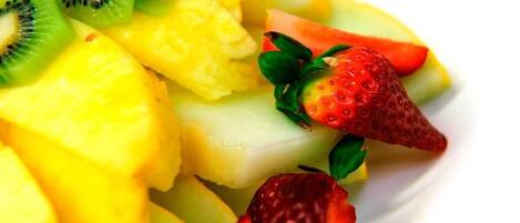 A close-up of a fruit salad with pineapple, kiwi, and strawberries.