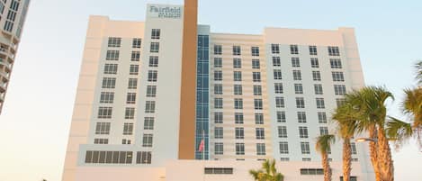 Un hotel de varios pisos con un letrero llamativo de Fairfield Inn & Suites by Marriott.