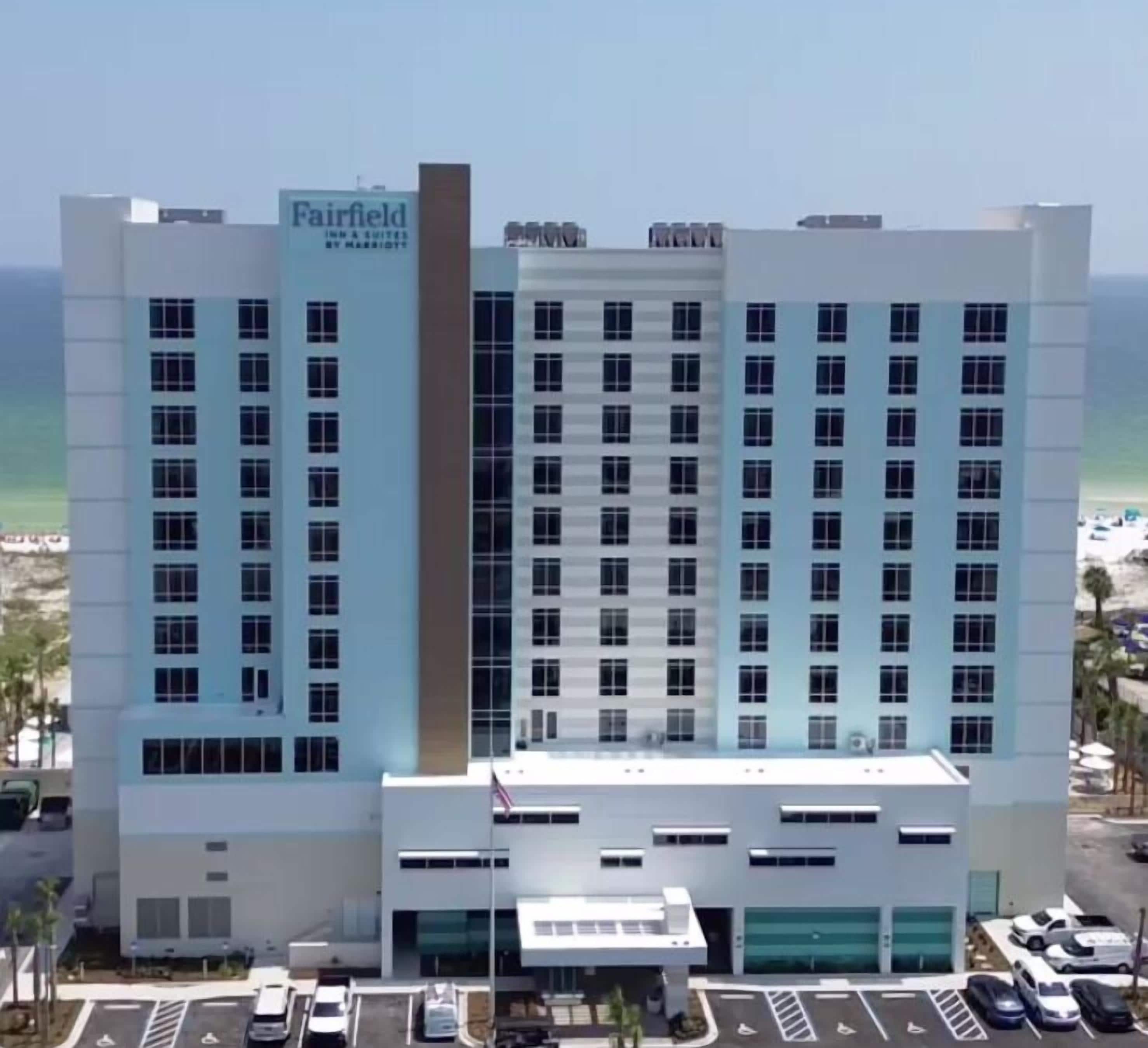 A multi-story hotel with a prominent sign for Fairfield Inn & Suites by Marriott.