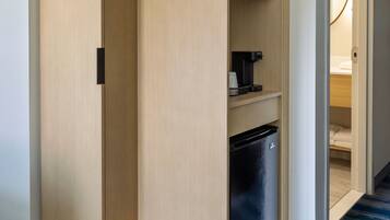 Un placard moderne, intégré, avec un micro-ondes et une machine à café placés sur les étagères.
