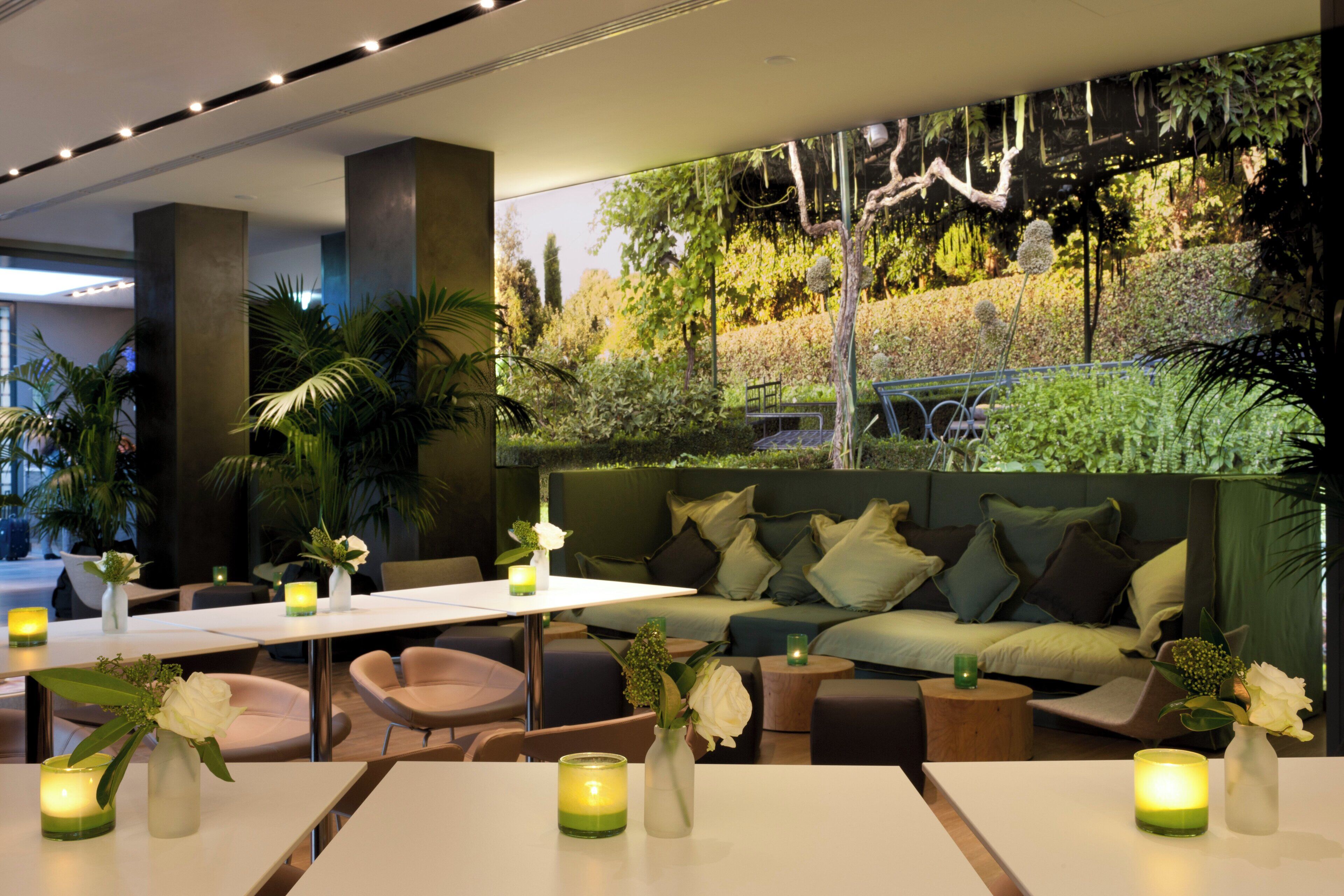 A modern interior with a dining area, seating, and a green wall with plants.
