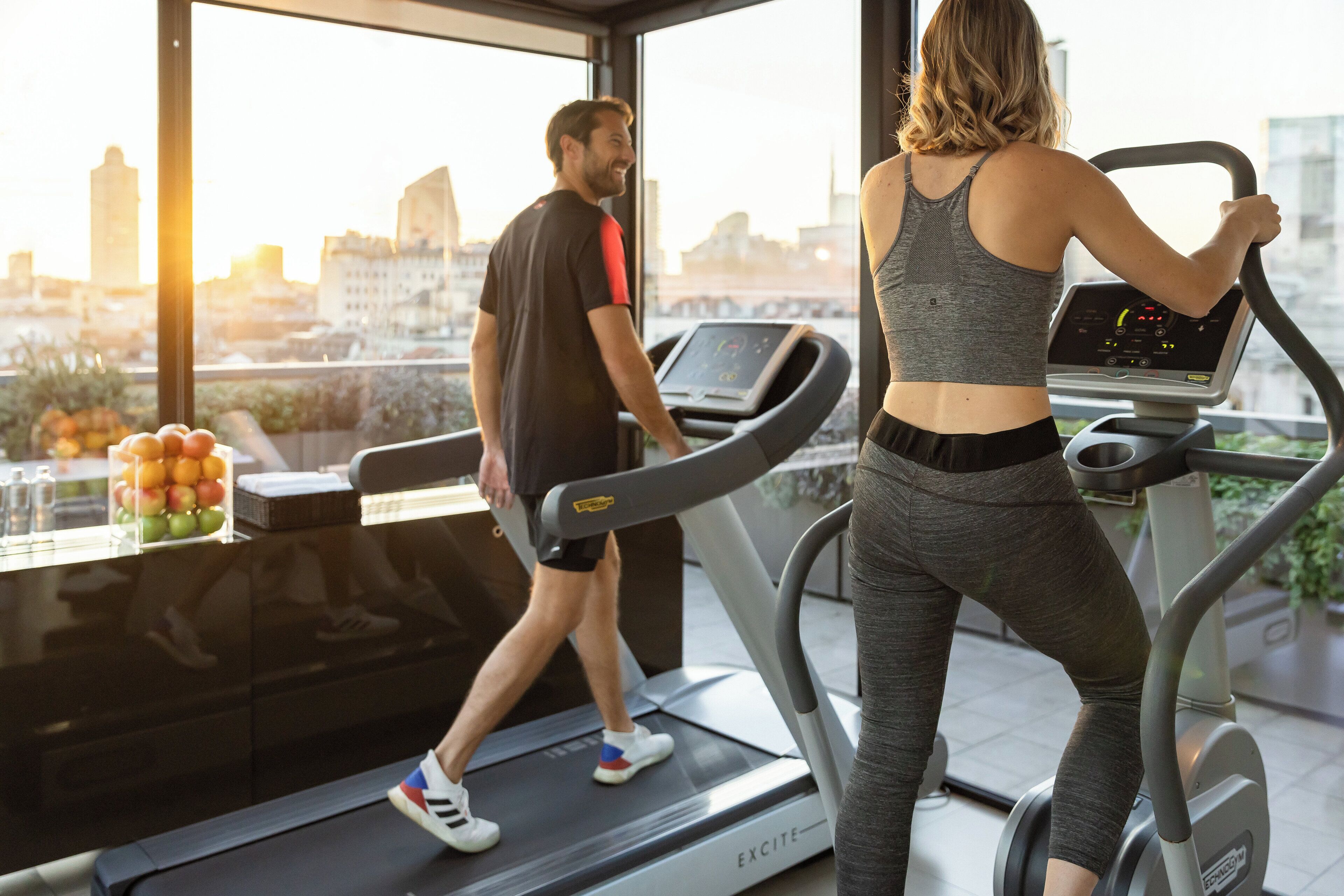A gym with treadmills and a city view.