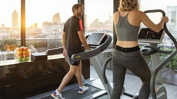 Un gimnasio con cintas de correr y vistas a la ciudad.