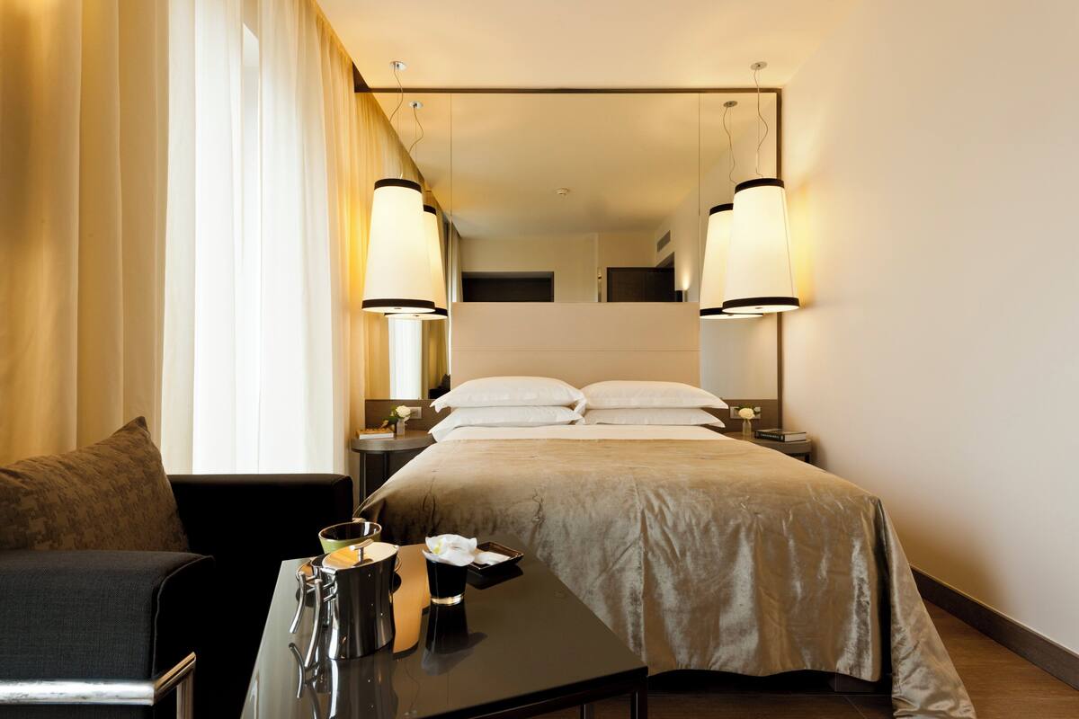 Une chambre d’hôtel comprenant un lit, des tables de chevet, un bureau et une chaise.