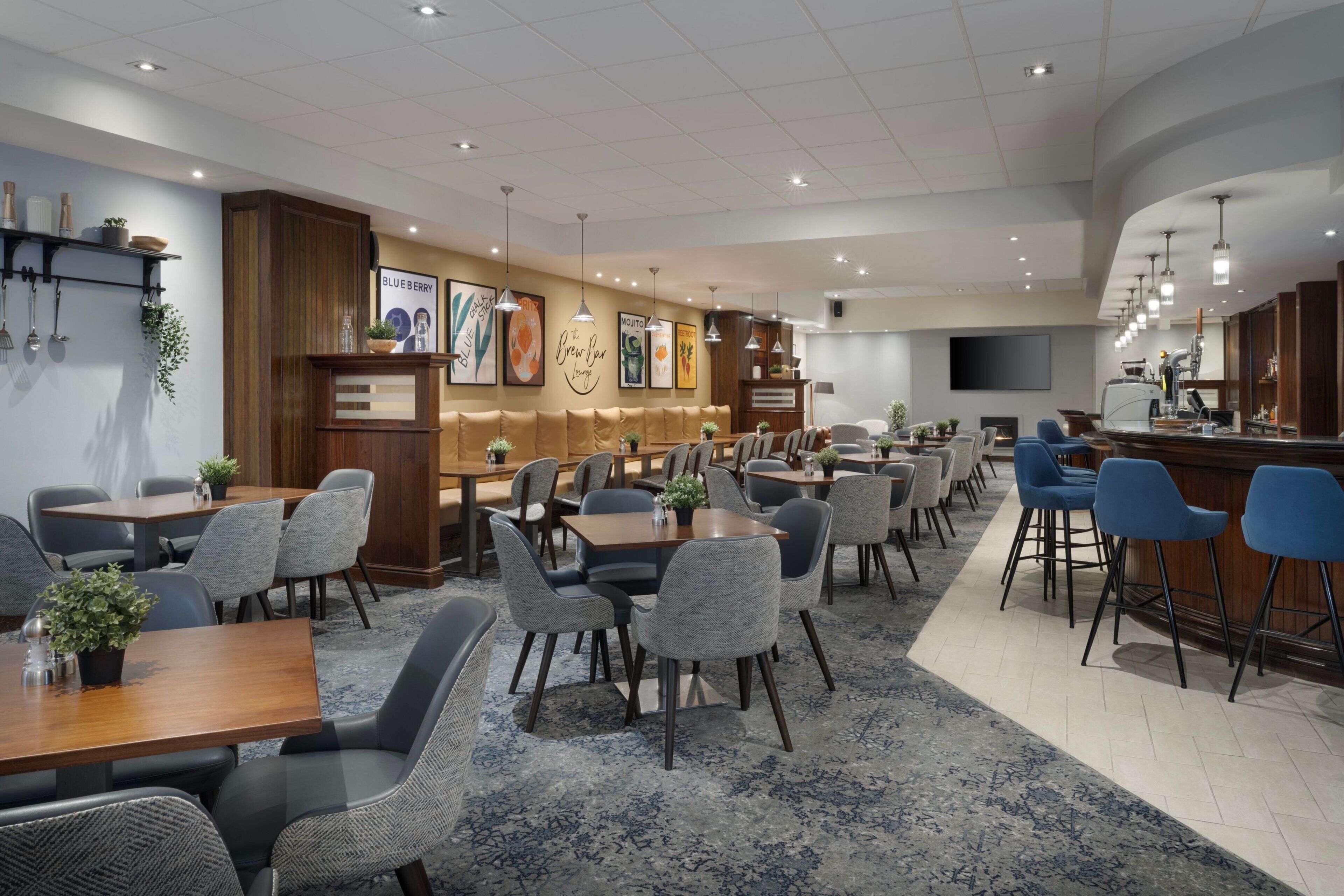 A modern restaurant with wooden accents, a bar area, and a seating arrangement for guests.