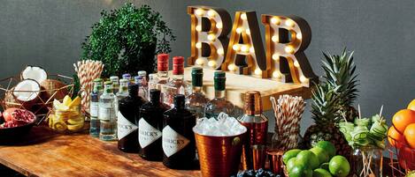 A bar setup with bottles, fruits, and a sign that reads "BAR".