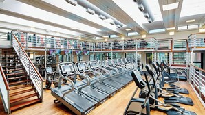Una àmplia sala de gimnàstica amb diverses cintes de córrer, escales i equip d'exercici.