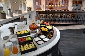 A breakfast buffet with various fruits, vegetables, and beverages.