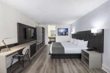 A spacious lobby with modern furniture, large windows, and a visible kitchen area. at Avanti International Resort